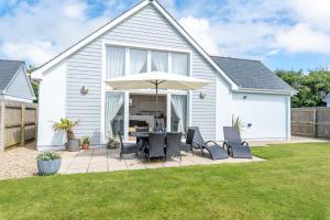 a patio with a table and chairs and an umbrella at The Sheiling in Woolacombe