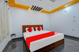 - une chambre avec un lit rouge et blanc dans l'établissement OYO Flagship Vasudha inn, Hoskote, à Bangalore