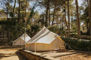 Zwei Zelte befinden sich in einem Hof. in der Unterkunft Camping Santa Elena in Lloret de Mar