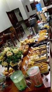 um buffet de sanduíches e outros alimentos sobre uma mesa em Hotel Garrafão - localizado no centro comercial de Boituva - SP em Boituva