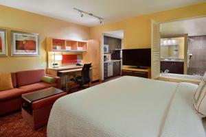 Habitación de hotel con cama y sala de estar. en TownePlace Suites by Marriott Thunder Bay en Thunder Bay
