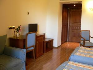 Pokój hotelowy z 2 łóżkami, biurkiem i stołem w obiekcie Benito Al Bosco w mieście Velletri