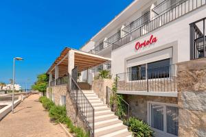 a building with a sign on the side of it at Boutique Hotel Oriola in Cala de Sant Vicenc