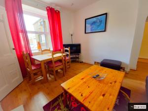 a living room with a wooden table and a dining room at Two Bedroom Penicuik Apartment in Penicuik
