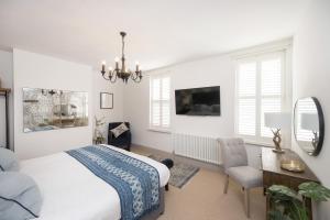 a bedroom with a bed and a desk and a tv at Townhouse by Harrogate Serviced Apartments in Harrogate