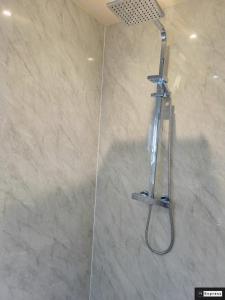 a shower with a shower head in a bathroom at Two Bedroom Penicuik Apartment in Penicuik