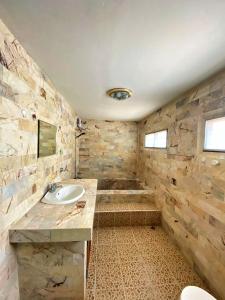 ein Badezimmer mit einem Waschbecken und einer Steinmauer in der Unterkunft 2BR Private Villa Natural Stone Style A3 in Ban Thalat Choeng Thale