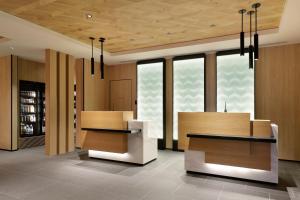 un vestíbulo con 2 escritorios y ventanas en un edificio en Fairfield by Marriott Kyoto Minamiyamashiro en Minamiyamashiro