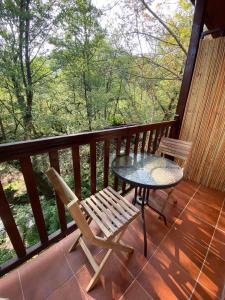 una mesa y sillas en un porche con vistas al bosque en GaliniCafe22-suites, en Kakopetria