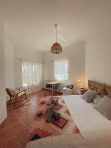 a bedroom with a large bed and a table at The Lighthouse Hostel Arrifana in Aljezur