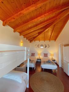 um quarto com 2 camas e um tecto de madeira em The Lighthouse Hostel Arrifana em Aljezur