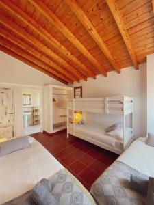 a bedroom with two bunk beds and a wooden ceiling at The Lighthouse Hostel Arrifana in Aljezur