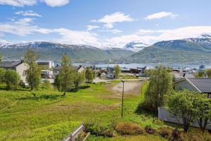 Blick auf eine Stadt mit Bergen im Hintergrund in der Unterkunft Sea & Mountain View Apartment Tromsø in Tromsø