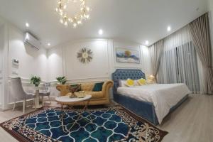 a bedroom with a bed and a couch and a table at Luxury econest - Apartment with swimming pool & gym in Hanoi +28 photos