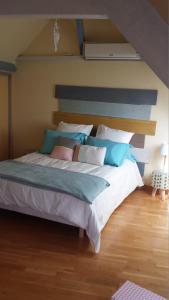 ein Schlafzimmer mit einem großen Bett mit blauen und weißen Kissen in der Unterkunft Appartement De La Vallée in Saint-Martin-le-Beau + 26 Fotos