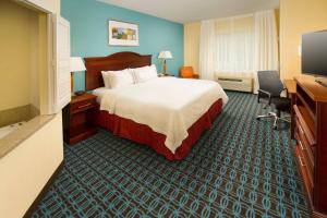 a hotel room with a bed and a flat screen tv at Fairfield Inn & Suites by Marriott Waco North in Waco