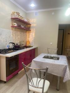 a kitchen with a white table and a stove at Жк Абырой Ризеденс in Atyrau