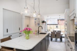 a kitchen with a vase of pink flowers on a counter at Townhouse by Harrogate Serviced Apartments in Harrogate