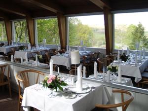 a room with tables and chairs with white tablecloths at Rold Storkro in Skorping