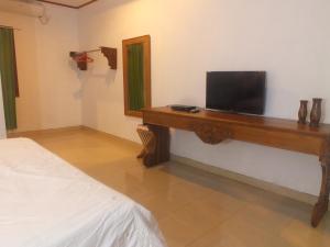 a bedroom with a desk with a television on it at Karimunjannah House in Karimunjawa
