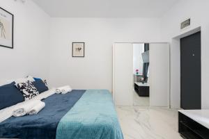 a white bedroom with a bed and a mirror at Blue-Line-Apartment-Unirii in Bucharest