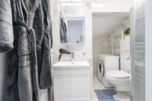 a bathroom with a white toilet and a sink at Blue-Line-Apartment-Unirii in Bucharest