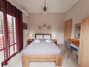 a bedroom with a bed and a desk in it at Ilias Apartments in Ýpsos