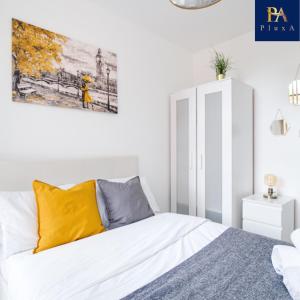a bedroom with a bed and a painting on the wall at Pluxa Waterside Apartment - Stylish 2bathrooms, walk to transit in Birmingham