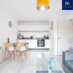 a kitchen and dining room with a table and chairs at Pluxa Waterside Apartment - Stylish 2bathrooms, walk to transit in Birmingham