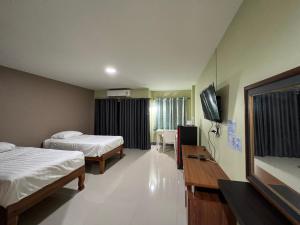 um quarto de hotel com duas camas e uma televisão de ecrã plano em V Tharm Hotel em Udon Thani