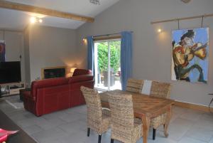 sala de estar con mesa de madera y sofá rojo en Casa del Sol en Arlés
