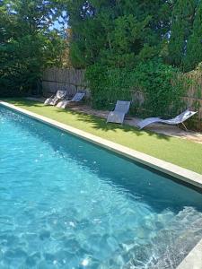 una piscina con 2 tumbonas en un patio en Casa del Sol, en Arles