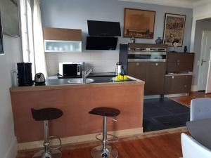 a kitchen with a counter and two bar stools at Les Embruns - Le Balcon - 2eme Etage in Deauville