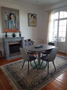 a dining room with a table and chairs and a fireplace at Les Embruns - Le Balcon - 2eme Etage in Deauville