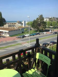 a green bench on a balcony with a view of a street at Les Embruns - Le Balcon - 2eme Etage in Deauville