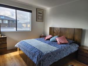 a bedroom with a bed with pink pillows and a window at Dream Family Retreat ! Escape Relax and Rejuvenate in Berwick
