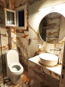 a bathroom with a toilet and a sink and a mirror at Azure Bliss Suites in Nikiti