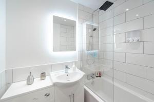 リバプールにあるLiverpool Harrow Road Sleeps 6- Infinity Apartmentの白いバスルーム(シンク、鏡付)