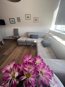 ein Wohnzimmer mit einem Sofa und einer Vase aus Blumen in der Unterkunft La torre house in Civitavecchia