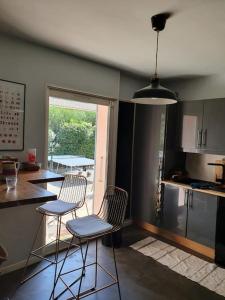 cocina con 2 sillas, mesa y barra en Villa Provençale la dolce vita, en Villeneuve-lès-Avignon