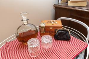 uma mesa com uma toalha de mesa vermelha e branca com uma garrafa de uísque em Stanley Helenski - apartment in old town em Šibenik