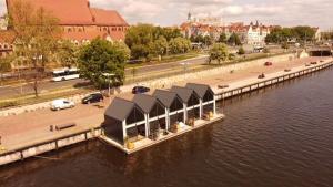a building on the side of a body of water at Floating Apartments - ODRA DREAM in Szczecin