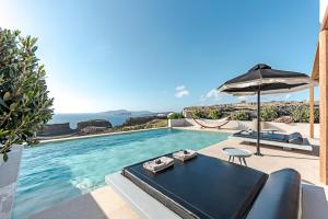 uma villa com uma piscina e um guarda-sol em Ambeli Sunset Villas em Megalochori