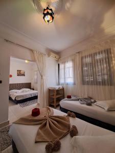 Habitación de hotel con 2 camas y lámpara de araña. en El Kennaria, en Marrakech