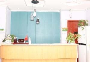 a kitchen with a counter and a blue wall at One Meter Sunshine Hotel Xi'an Xianyang International Airport Flagship Store in Xianyang