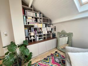 ein Wohnzimmer mit einem Spiegel und Bücherregalen in der Unterkunft Loft de Juliette à Saint-Malo in Saint-Malo