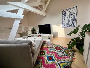ein Wohnzimmer mit einem Sofa und einem Teppich in der Unterkunft Loft de Juliette à Saint-Malo in Saint-Malo