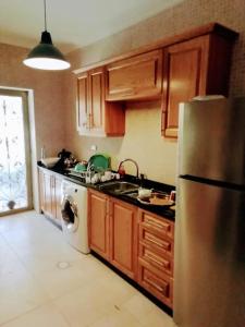 uma cozinha com um frigorífico de aço inoxidável e uma máquina de lavar louça em Apartment with terrace garden em Amã