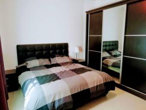 1 dormitorio con 1 cama grande y espejo en Apartment with terrace garden en Amán