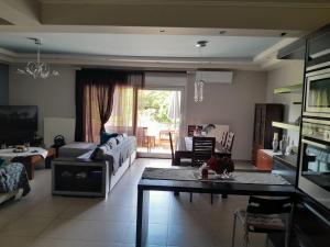 ein Wohnzimmer mit einem Sofa und einem Tisch in der Unterkunft FAMILY HOUSE in Kavala